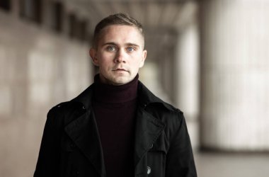 Siyah trençkotlu şık adam.