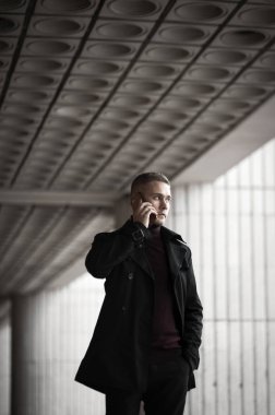 Siyah trençkotlu şık adam.