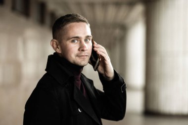 Siyah trençkotlu şık adam.