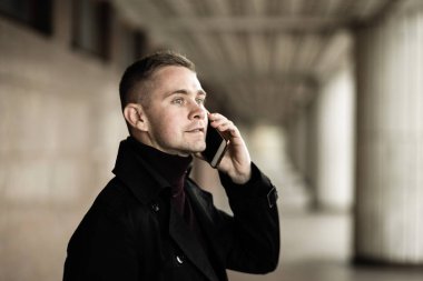 Siyah trençkotlu şık adam.