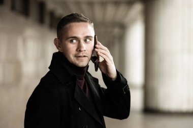 Siyah trençkotlu şık adam.