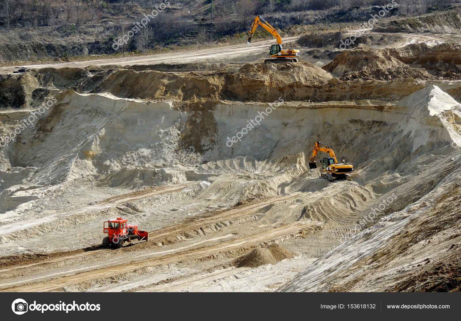 Heavy excavators and bulldozer works into industrial sand quarry Stock