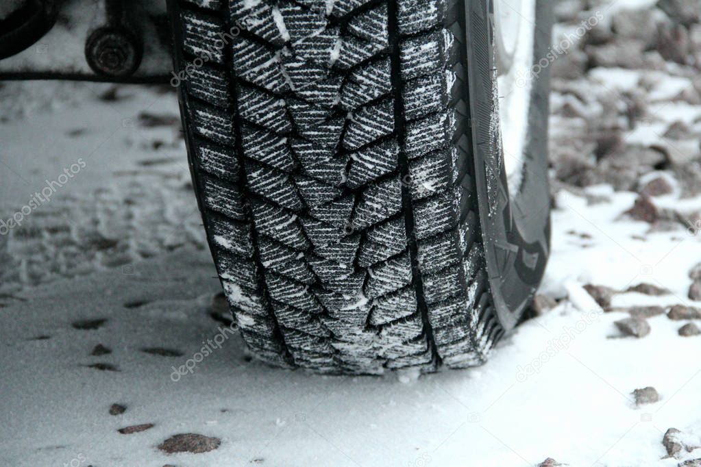 Winter tire tread blocks packed with the snow closeup