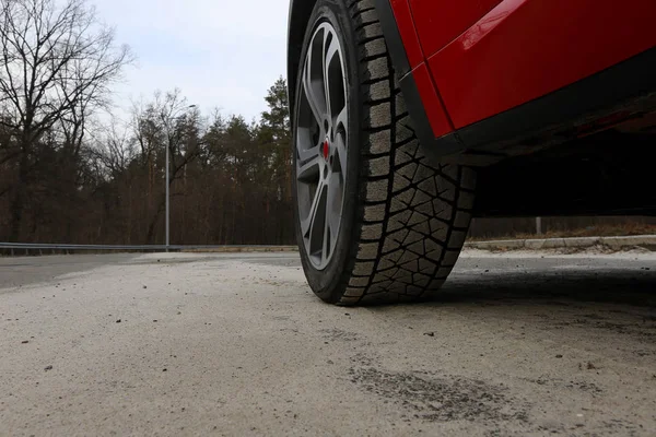 タイヤに砂が道路に赤い車の前輪のトレッドします — ストック写真