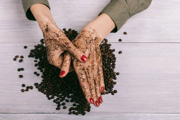 Young woman massaging a hand with coffee scrub