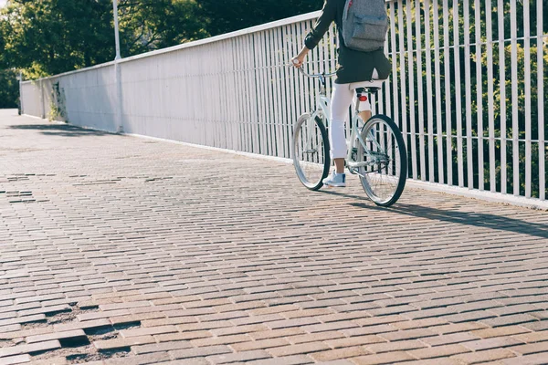 Slender woman riding a city bike on a sunny morning