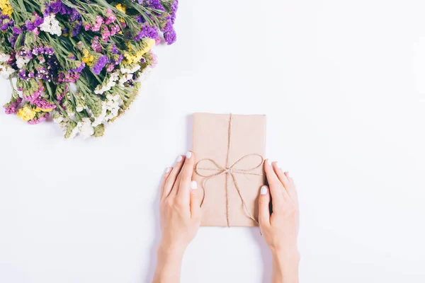 Female hands pack the holiday gifts on a white table