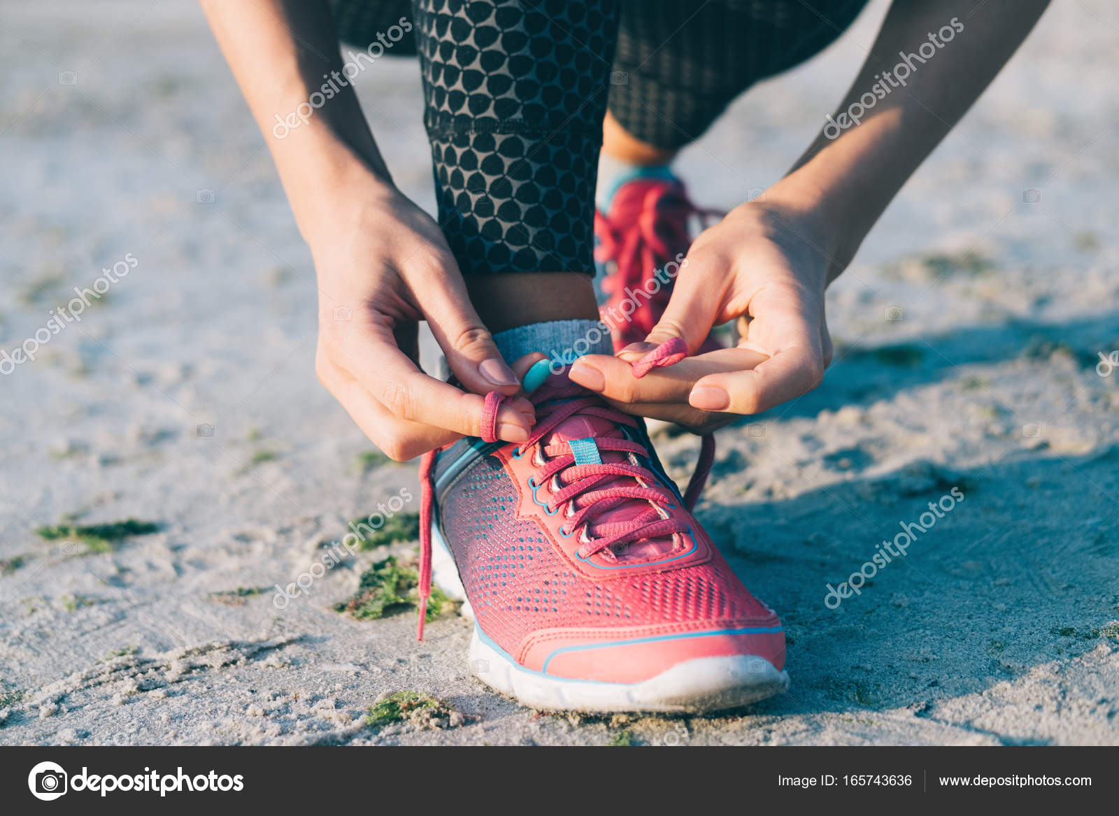 Girl tying shoelaces on sneakers 