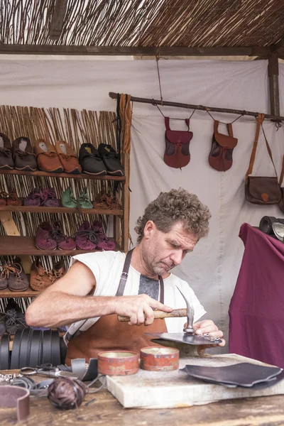 Leather man working in a medieval market in Avila