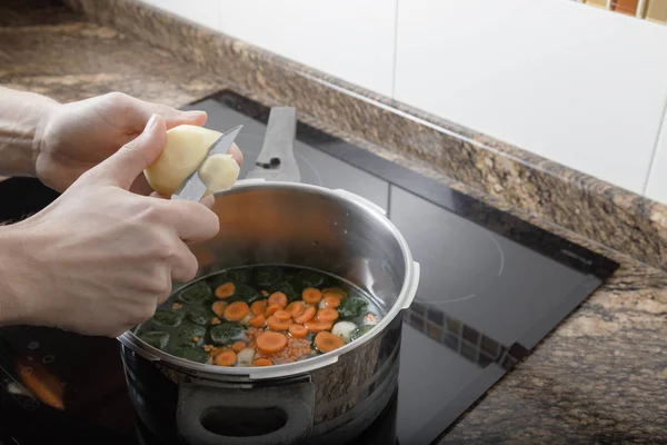 Homem cozinhando um guisado — Fotografia de Stock