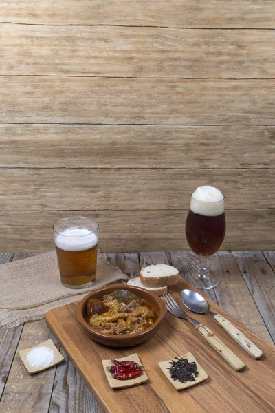 Mesa de madera con plato de barro con vasos de carne y cerveza — Foto de Stock