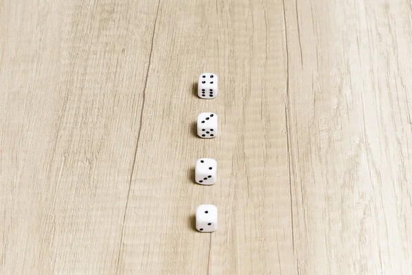 group of dice for a game of chance on a light colored wooden table