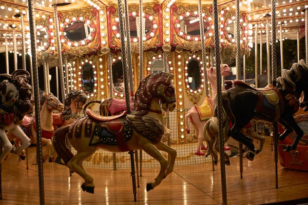 Horses on a merry-go-round with lights on a Christmas night — Stockfoto
