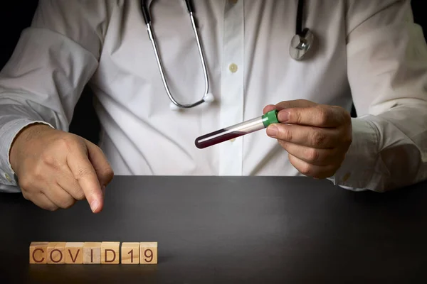 Cubos Madera Con Palabra Covid Junto Médico Que Sostiene Tubo —  Fotos de Stock