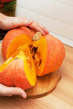 Bir adam olgun, güzel, sulu bir kabak keser!