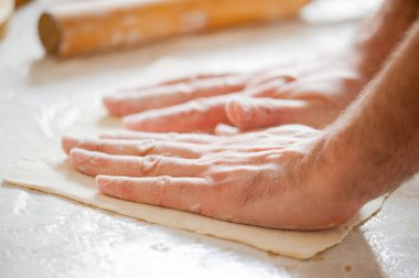 Masanın üzerine un aşçı el rulo hamur, malzemeler.