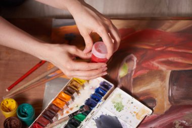 Bıyık boyalarıyla yapılmış usta bir çizim, natürmort. Boya kutuları ve fırçalar ustanın eli..