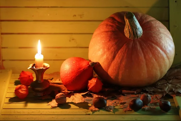 pumpkin and lamp on wooden table