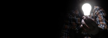 Karanlıkta parlayan ampul ile adam