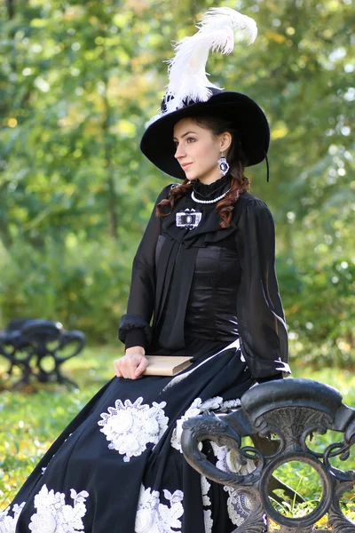 Girl in retro dress past century read letter on bench — Stock Photo, Image