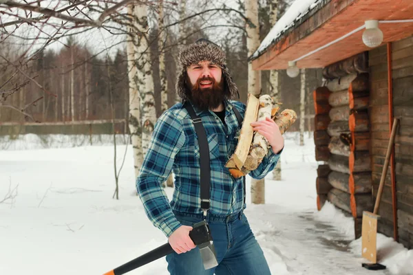 Человек зимой с топором — стоковое фото
