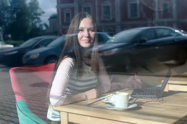Girl behind glass in cafe — Stock Photo, Image