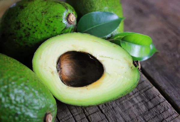 Aguacate y aceite sobre fondo de madera — Foto de Stock