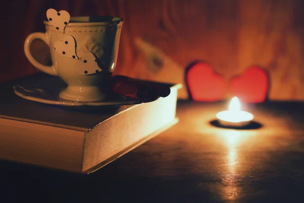 Petite tasse sur livre rétro et bougies — Photo