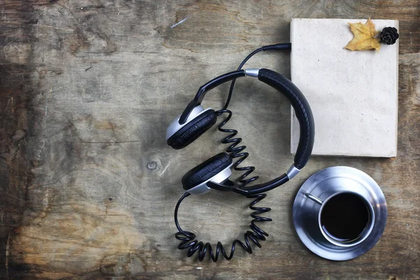 Auriculares audiolibros y libro sobre mesa de madera — Foto de Stock