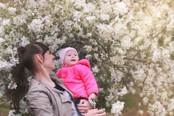 Mamma med bebis i apple trädgård — Stockfoto