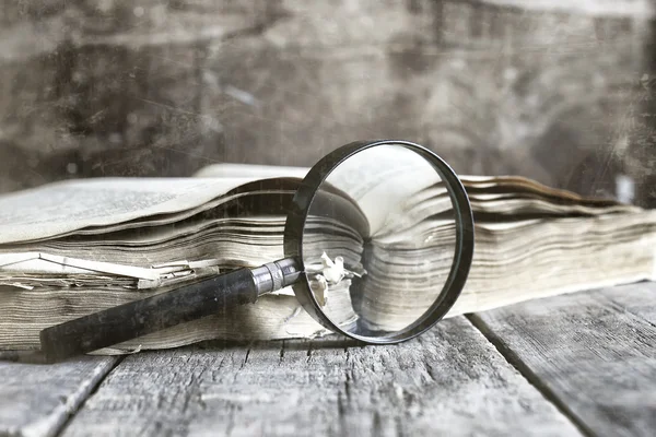 Old scratched effect on photo magnifying glass and old book — Stock Photo, Image
