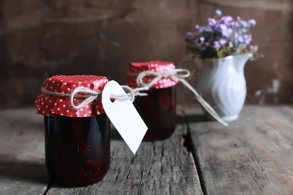Rustic homemade jam jar wooden background and flower — Stock Photo, Image