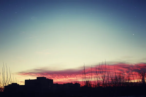 Red sunset sky silhouettes of buildings — Stock Photo, Image