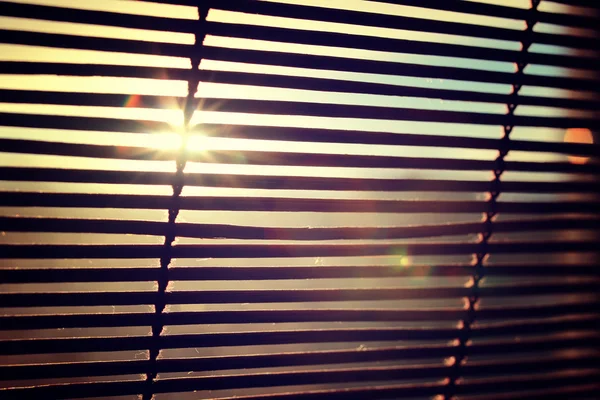 glare from bright sunlight through the wooden Rom Blinds