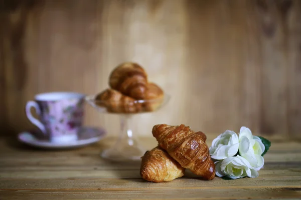 Taza croissant desayuno fondo de madera — Foto de Stock