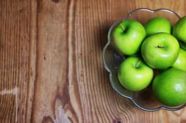 bir cam kase ahşap arka planda yeşil elma