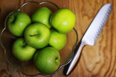 bir cam kase ahşap arka planda yeşil elma