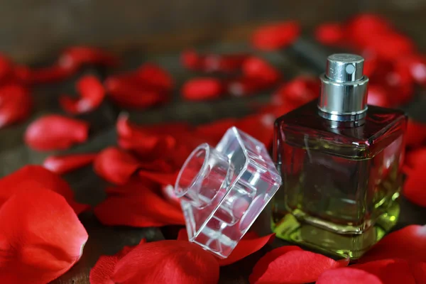 Perfume bottle and petals — Stock Photo, Image