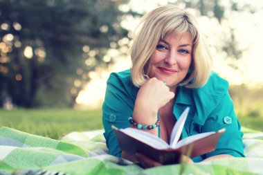 kadın yatıyordu ve kitap Güneş okuyun