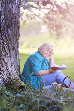 kadın parkta günbatımı kitap ile
