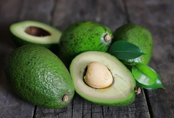 Aguacate y aceite sobre fondo de madera — Foto de Stock