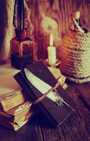 Ρετρό αντικείμενα φτερό και leaher βιβλίο με φως των κεριών — Φωτογραφία Αρχείου
