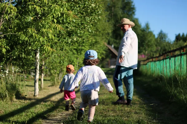 Dos niños caminar abuelo — Foto de Stock