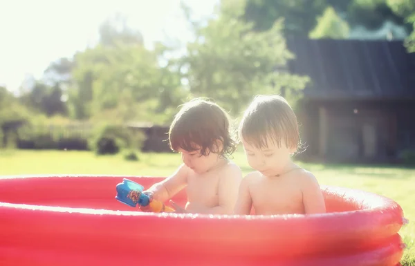Bebê espirrando na piscina ao ar livre — Fotografia de Stock