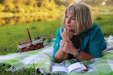 kadınla çimenlerin üzerinde kitapla Park