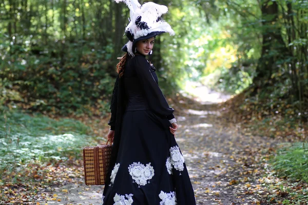 Menina em vestido retro do século 18 com valise no parque — Fotografia de Stock
