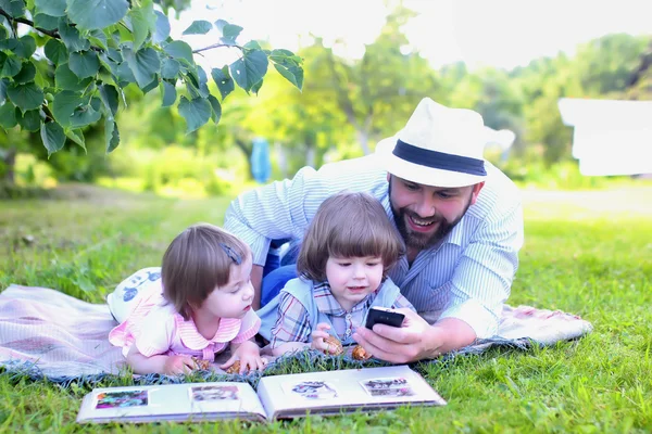 Rodina v přírodě položit travní — Stock fotografie