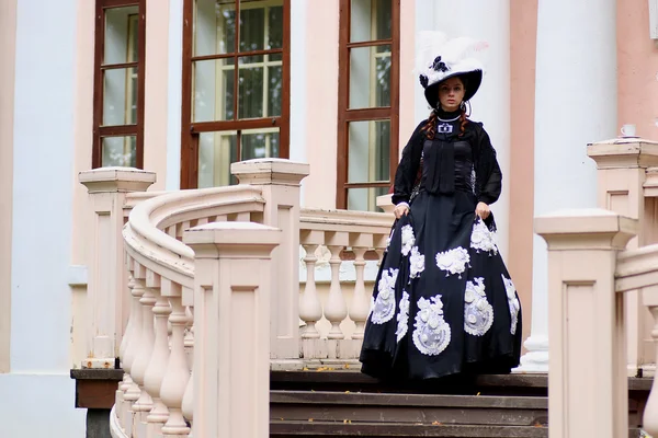 woman in vintage dress on porch of castle