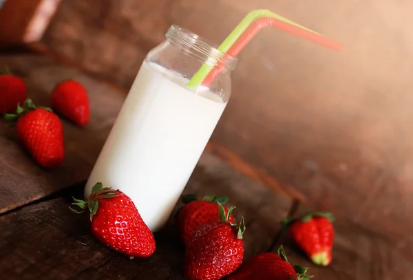 Mesa de madera con fresas y leche en un vaso —  Fotos de Stock