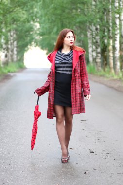 kadın bir yağmurluk ve şemsiye